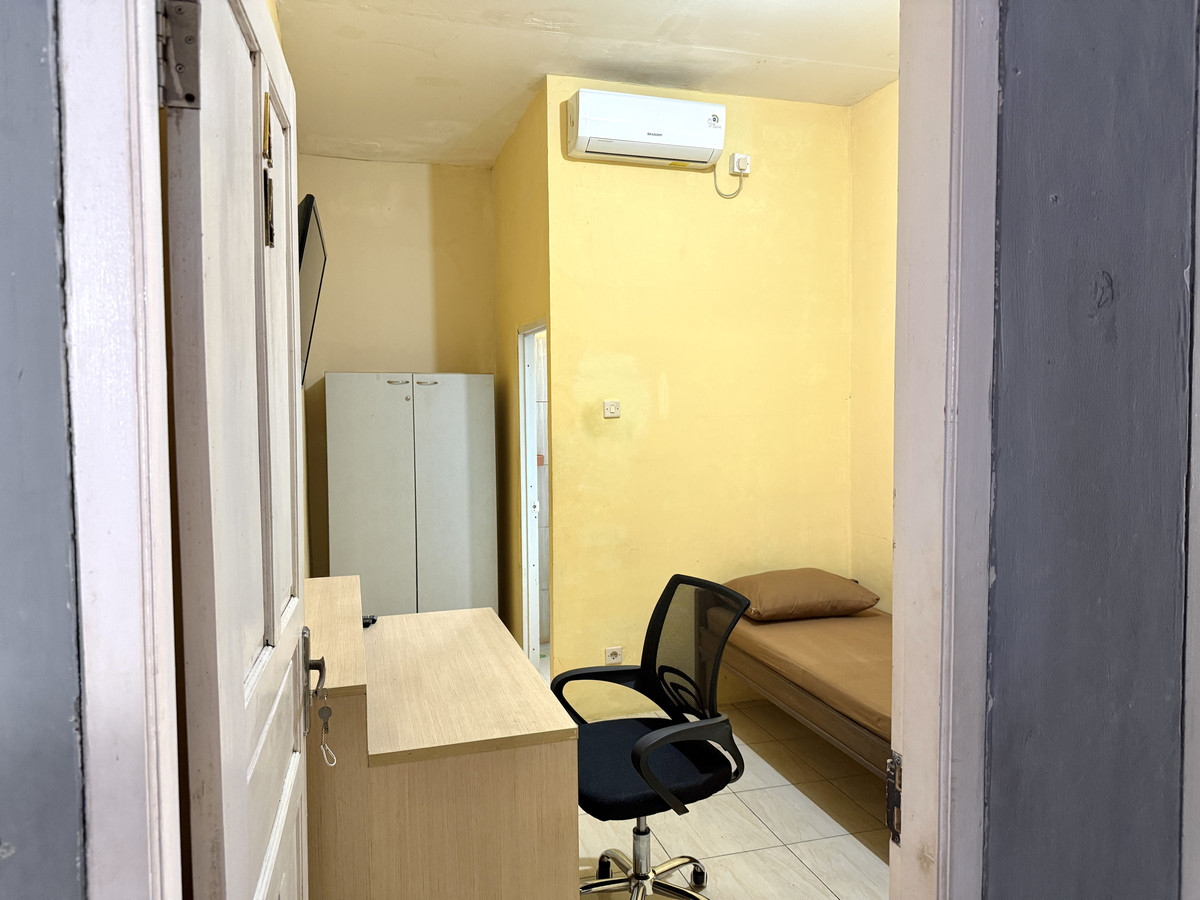 Kamar Tipe B dengan tempat tidur, meja belajar, lemari, dan AC