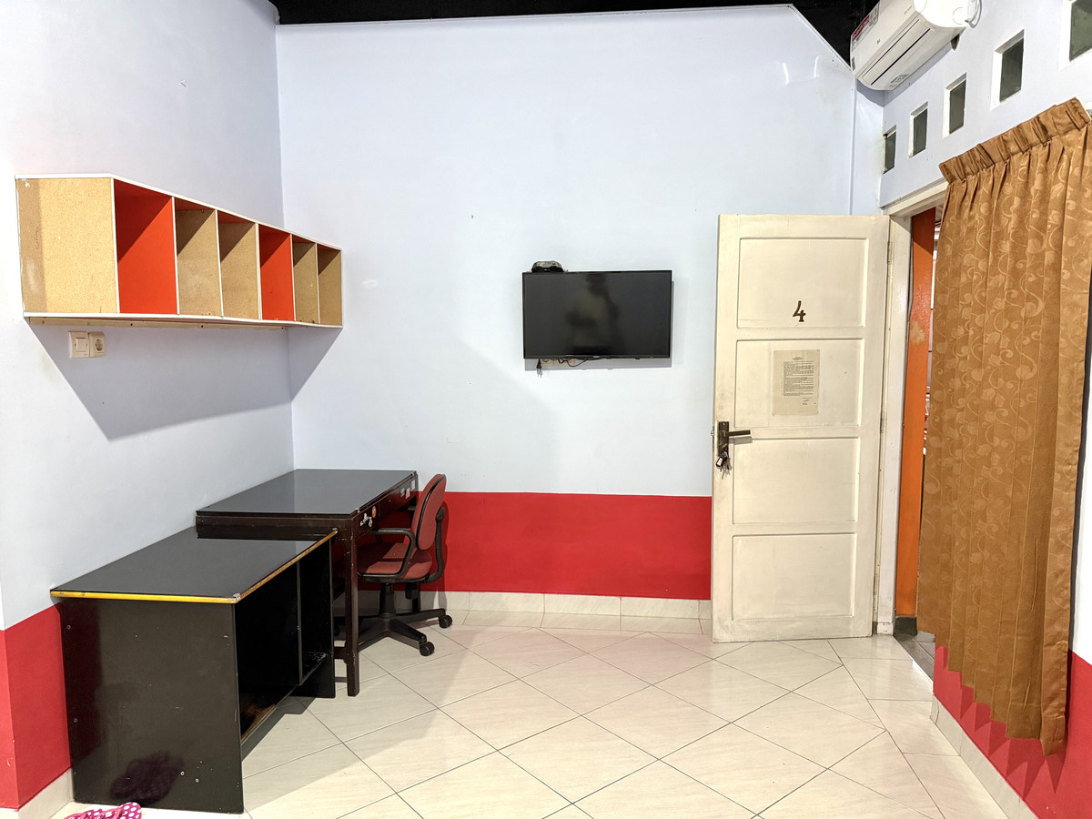 Kamar Tipe C, kamar pojok yang paling luas, dengan meja belajar, rak, dan TV